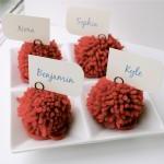 Red yarn pom pom place holders. Wed..